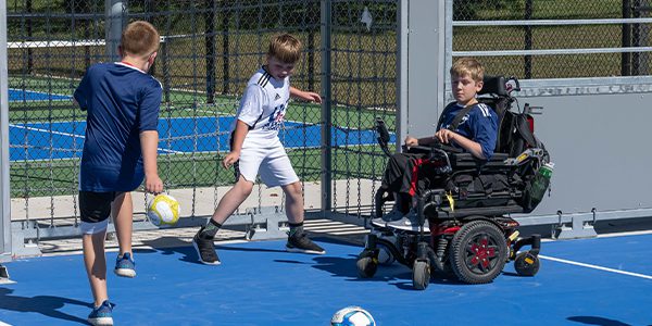 Campers play soccer on new Mini-Pitch System™ Modular Sports Solution, part of the new Multipurpose Field at Camp Courageous.