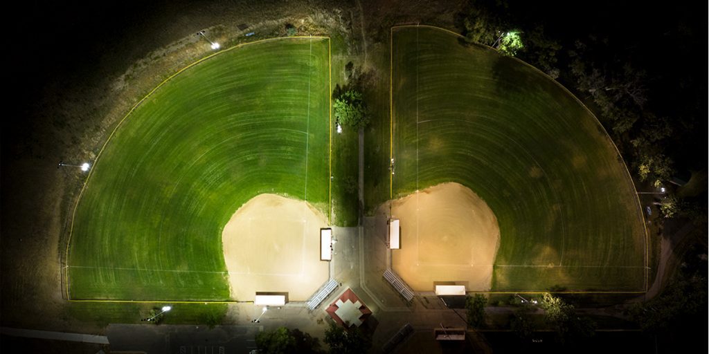 Baseball field on the left is uniformly lit after upgrade to Musco LED sports lighting, versus field with HID lighting on the right.