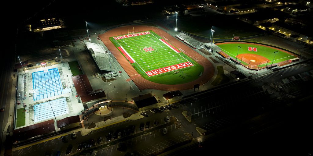 Hollister High School football, baseball, and aquatic center lit at night with minimal light spill and glare to surrounding areas after upgrading to Musco LED sports lighting system