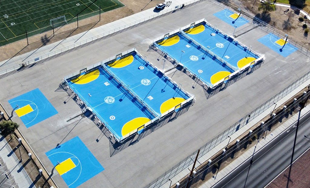 Four soccer mini-pitches with light blue and yellow surfaces at Freedom Park