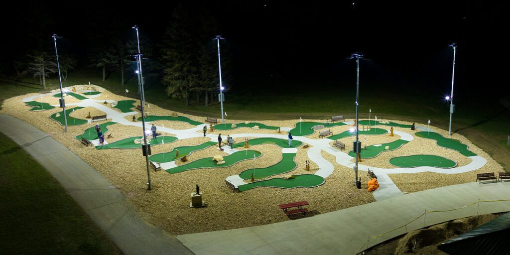 Accessible mini-golf course at Camp Courageous is lit at night with LED lights