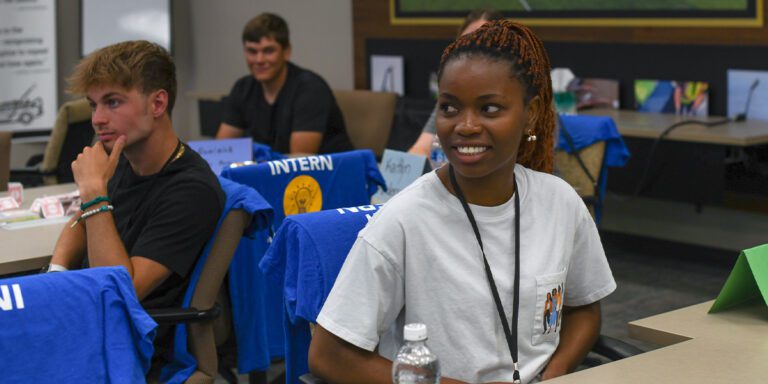 Smiling female intern engaging with someone off camera during an intern event at Musco Lighting.