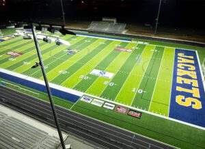 Overhead view of Wynne High School football field with Musco LED lighting fixture and pole in the foreground.