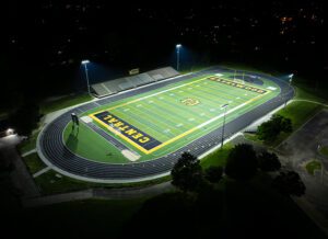 Hazelwood Central High School's football field with black and gold end zones lit at night.