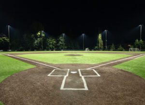 Woodinville High School baseball diamond showing the field lit at night from behind home plate.