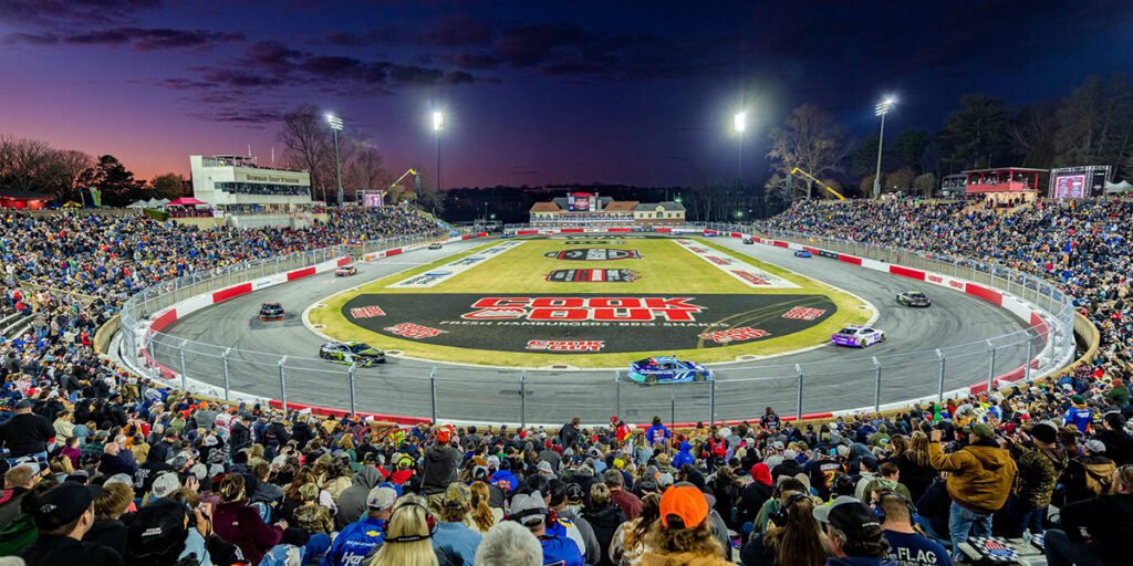 NASCAR fans watch night racing at Bowman Stadium with Musco mobile LED lighting in the background.