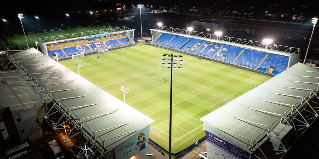 Temporary LED lighting system with Croud Meadow soccer field and blue stands in the background.